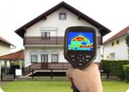 Infrared camera image showing heat loss on a house
